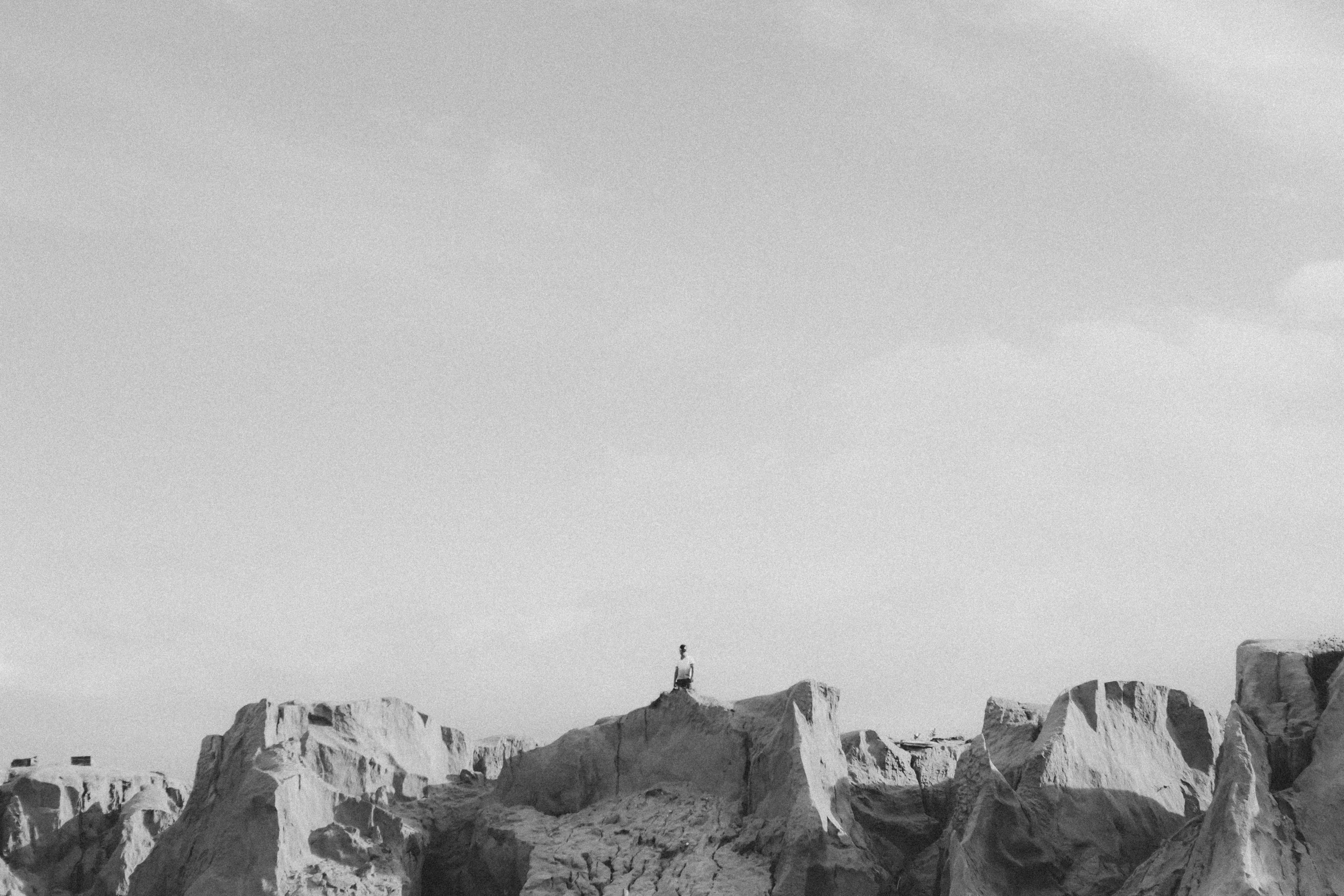 a boat on the shore near mountains in black and white