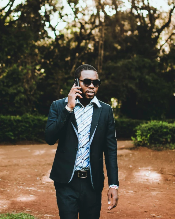 a man walks as he holds a phone to his ear