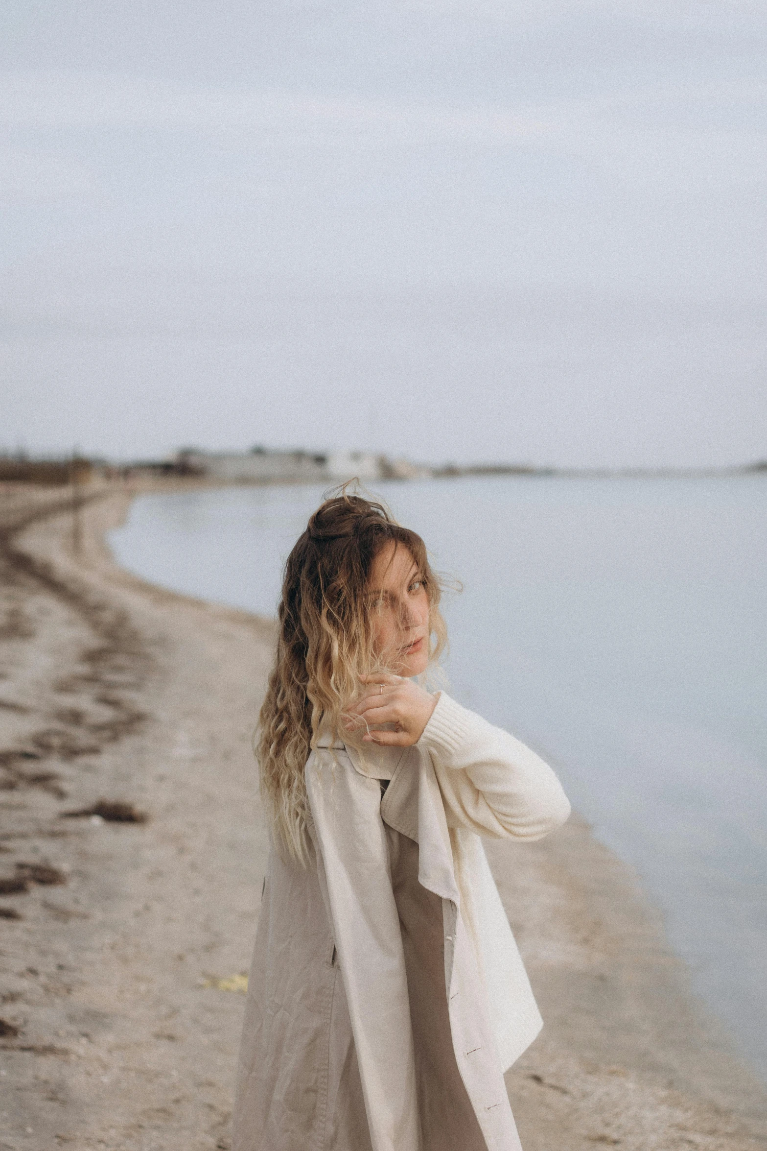 a woman posing on the shore of the lake