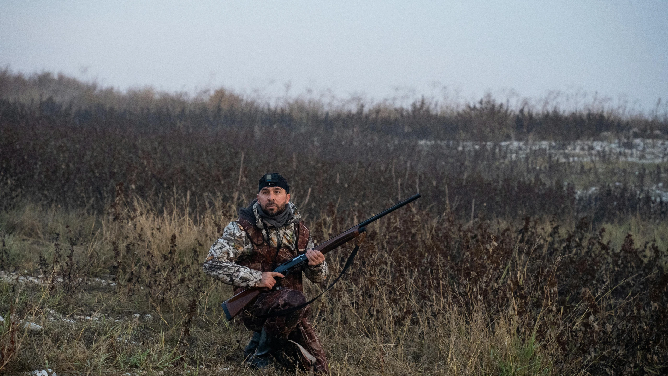 a man holding a sgun in a field