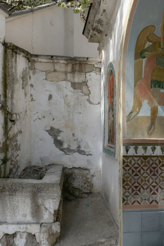 a dilapidated and crumbling wall with a bench in the corner