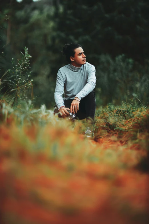 a man sitting on a rock in the woods