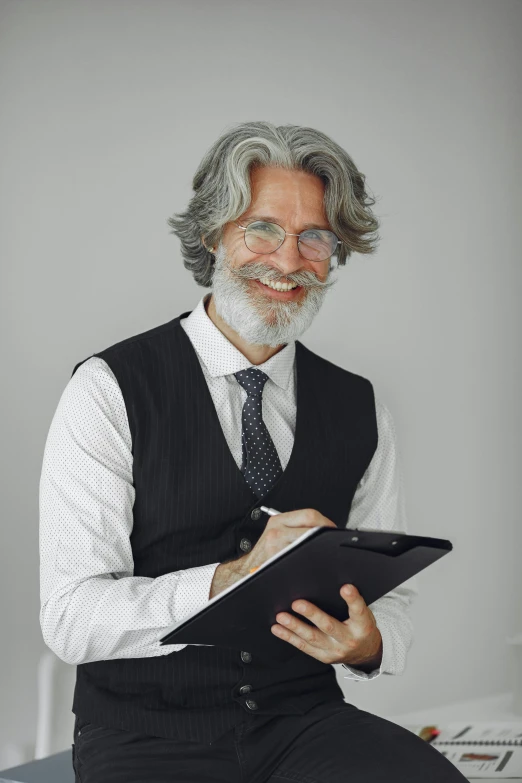 an older gentleman sitting on top of a desk while looking at his file