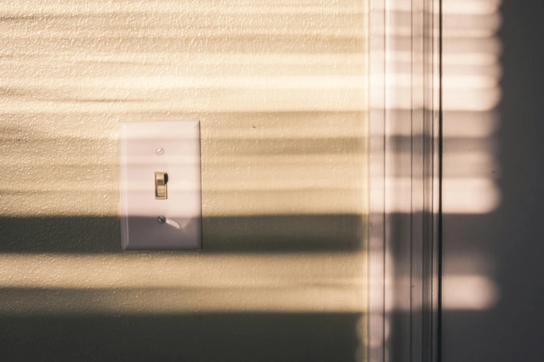 a small light switch with sunlight shining on it
