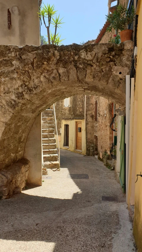 an archway leads into a courtyard with stone walls