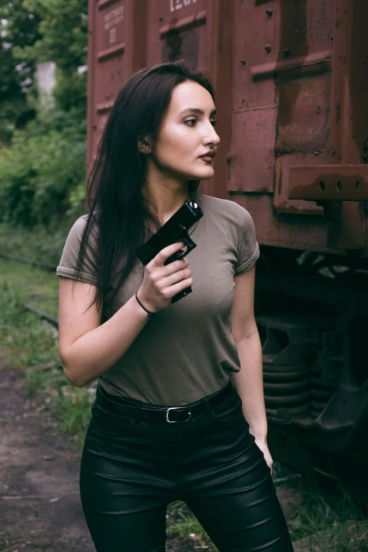 a beautiful young woman holding onto a pistol