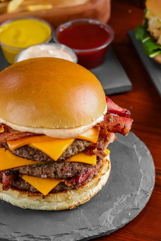 cheeseburger, bacon, fries and condiments on a plate