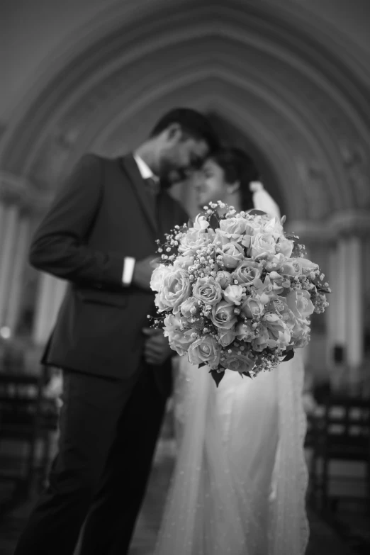 a beautiful bride and groom in the church kiss as they stand before the camera