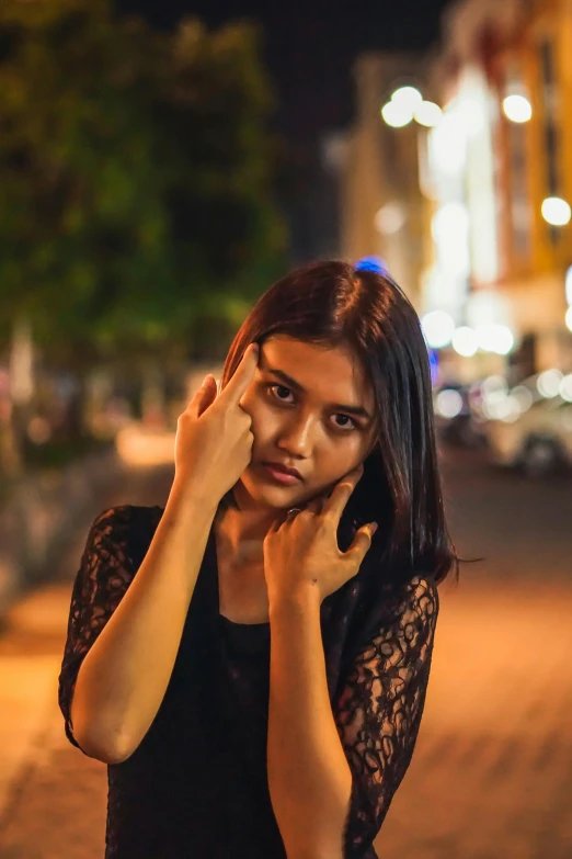 a woman with her hands under her face on the side of the road