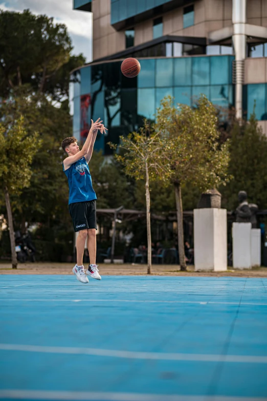 a  trying to dunk a basketball at an outdoor court