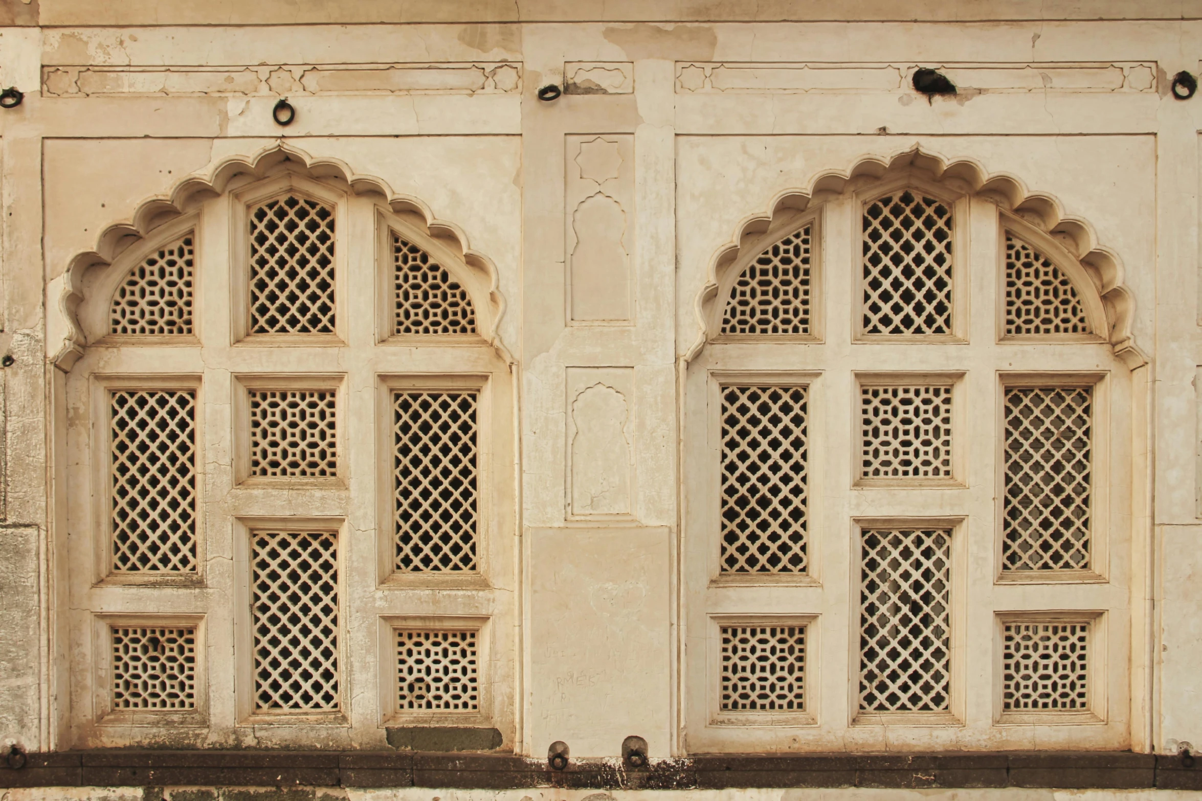 a white wall with decorative windows in a building