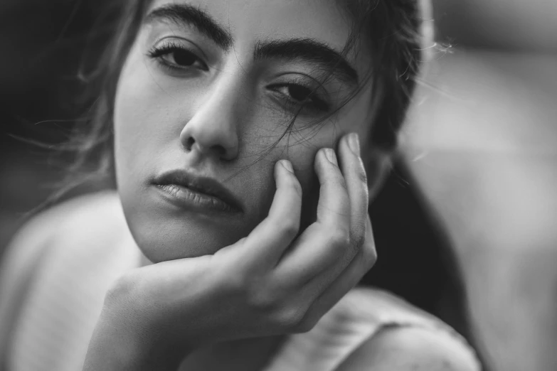 a black and white po of a woman holding her hand on her face