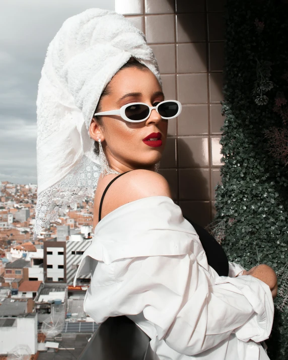 a woman wearing sunglasses and a white veil on top of her head