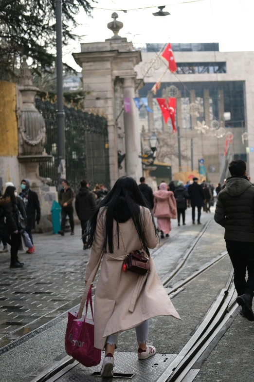 a woman holding onto her purse while crossing a street