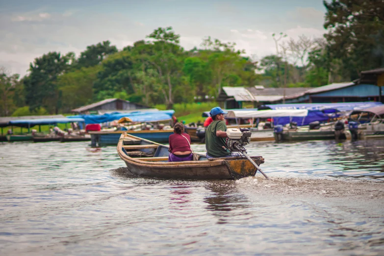 two people are riding in a boat on the water