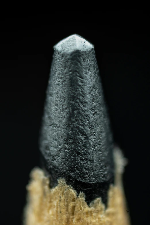 a close up view of the tip of an artistic pencil with black and brown shading