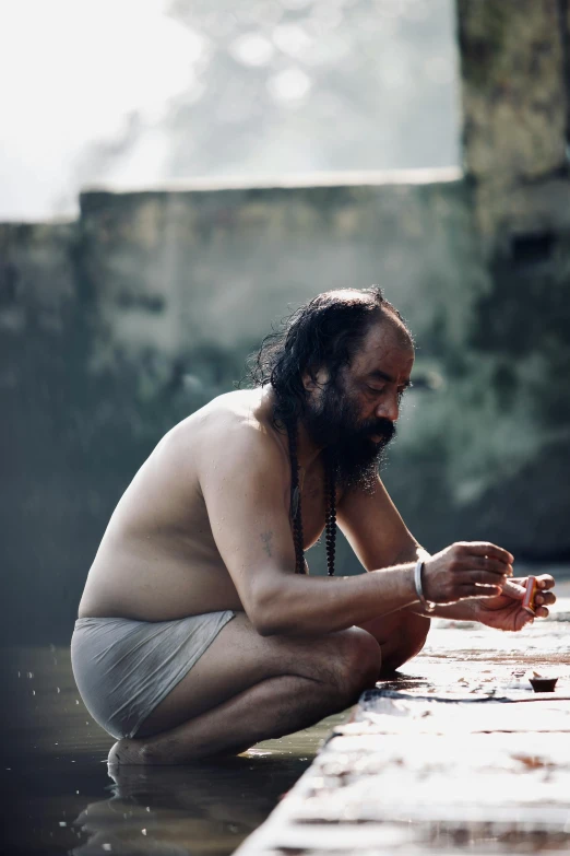 a man sits at a large wooden table eating food