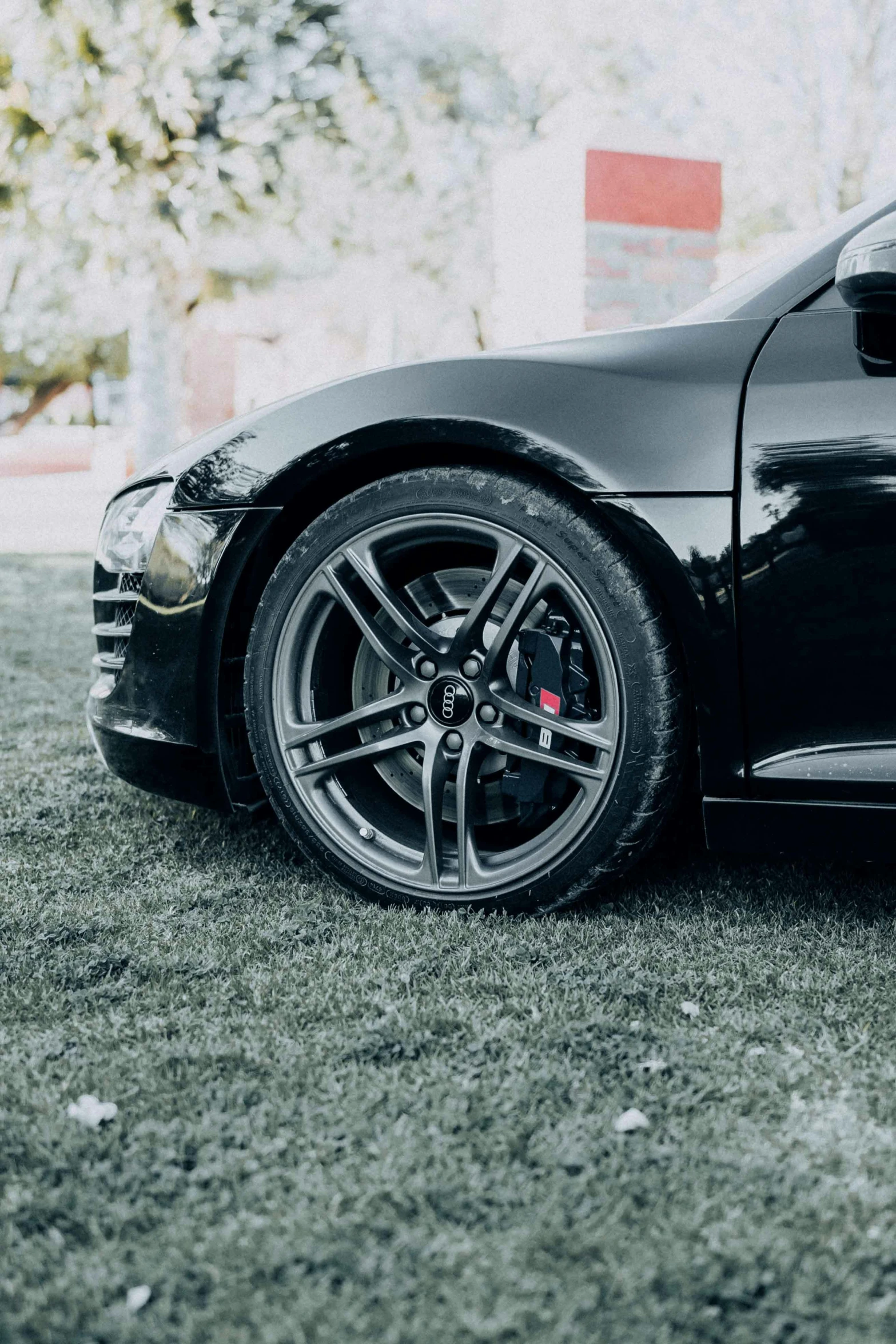 a black sports car parked in a grass area