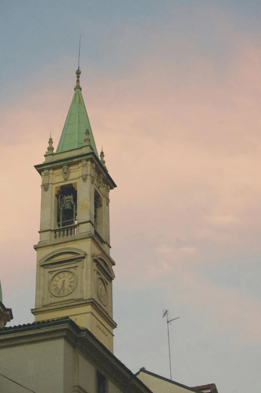 the steeple of a tall building has a clock on it