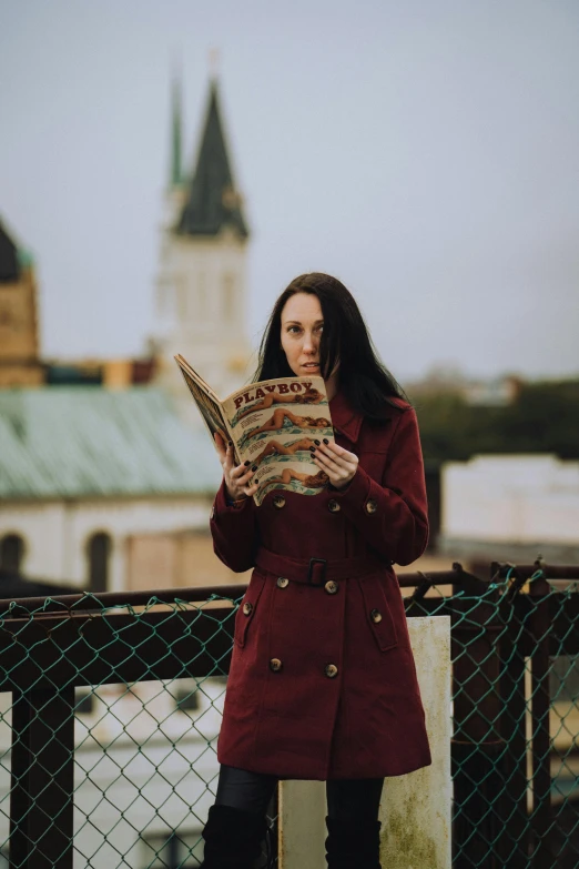 a woman is reading in a red coat