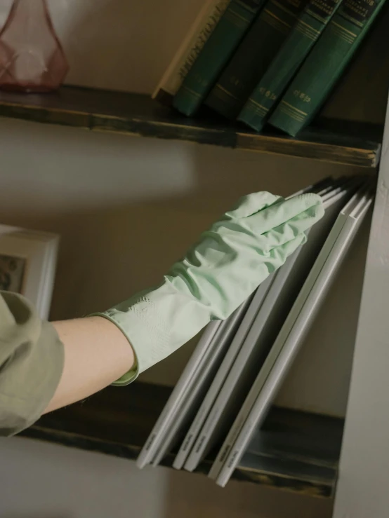 a hand that is sticking a curtain onto a book shelf