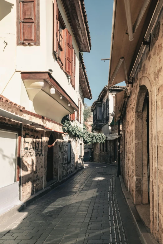 a street with a row of buildings next to a cobblestone sidewalk