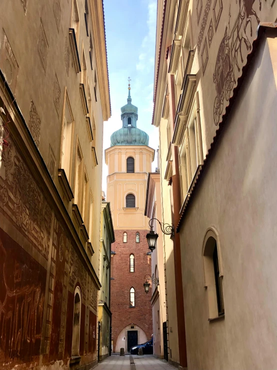 a narrow street leads to two towers in a historical area