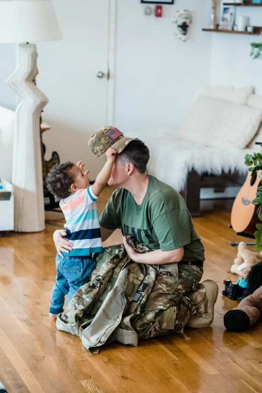 man and young child kneeling on floor with guitars in the background