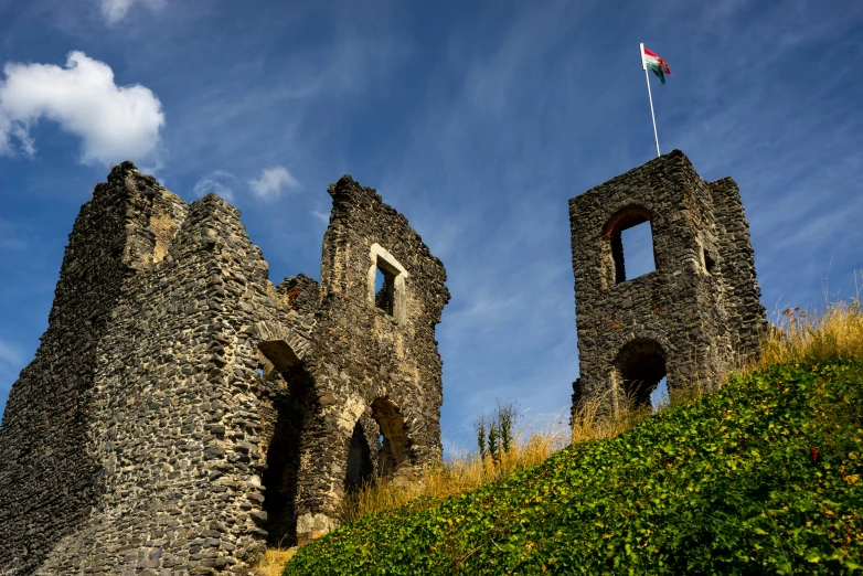 a castle style structure sitting on a grassy hillside