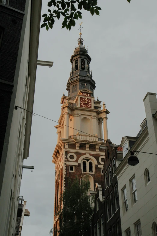 tall clock tower in the center of some small buildings