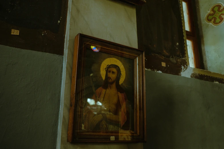 a picture frame hanging next to the wall with a painting on it