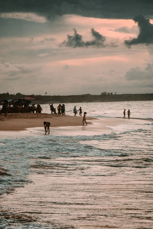 a group of people walking on the beach