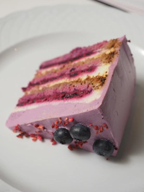 a piece of cake on a plate topped with berries