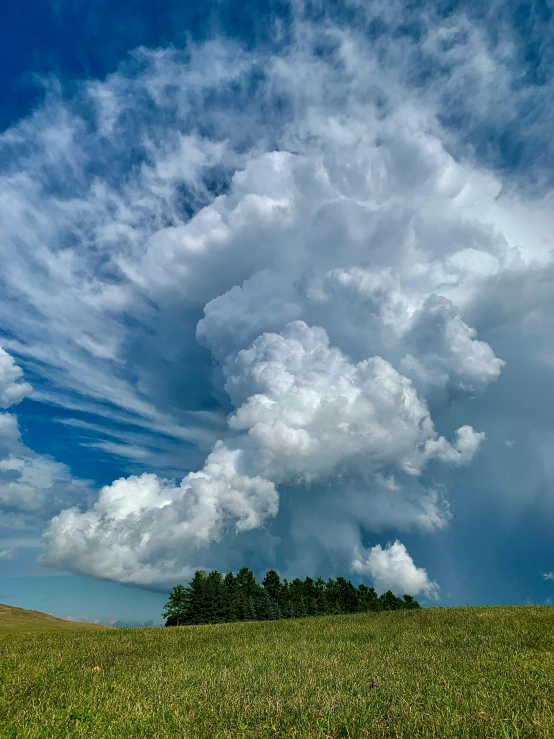 an ominous cloud over a grassy hill