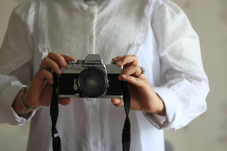 a person wearing white holding a camera in their hand