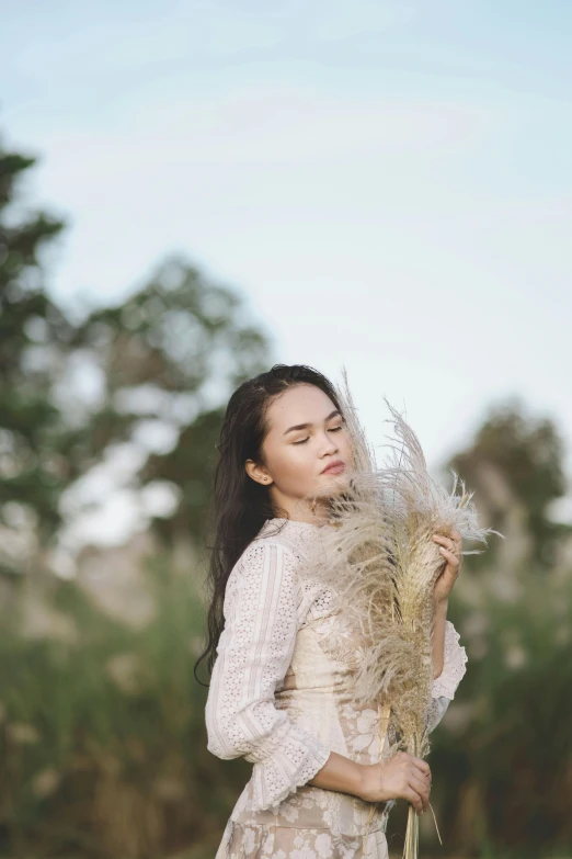 a woman in a dress holding some kind of plant