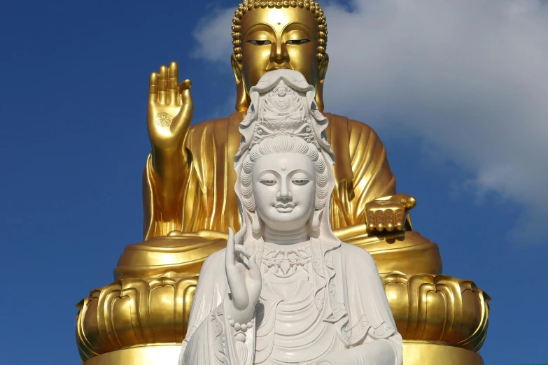 a gold buddha statue standing behind the golden buddha