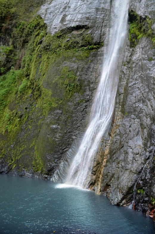 a waterfall pouring from the side of a cliff into the ocean