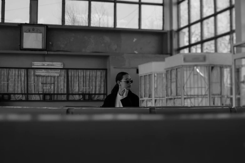 a woman in sunglasses sitting and talking on her cellphone