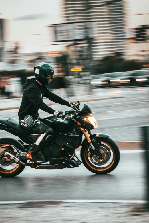 a person riding a black motorcycle on a city street