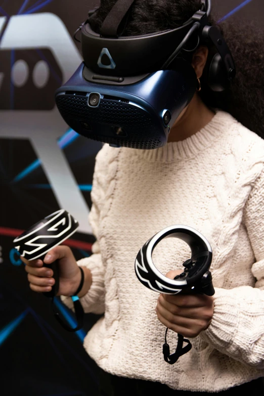 a woman wearing virtual gear holding two controllers