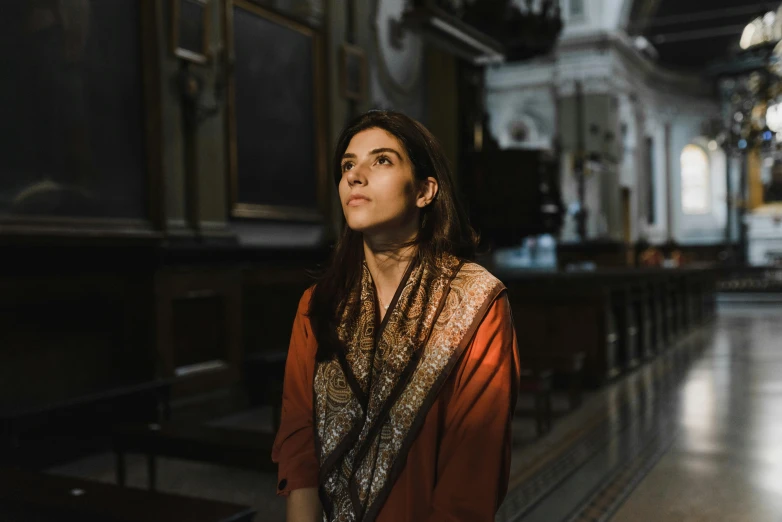 a woman standing in a church looking up