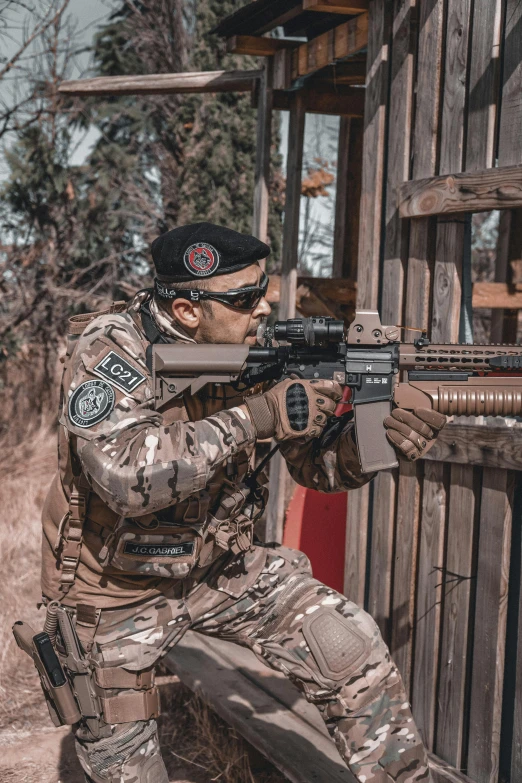 a man in camouflage holding a gun on his back