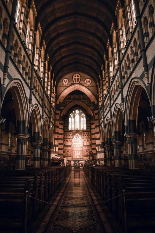 a building filled with stone pillars and wooden pews