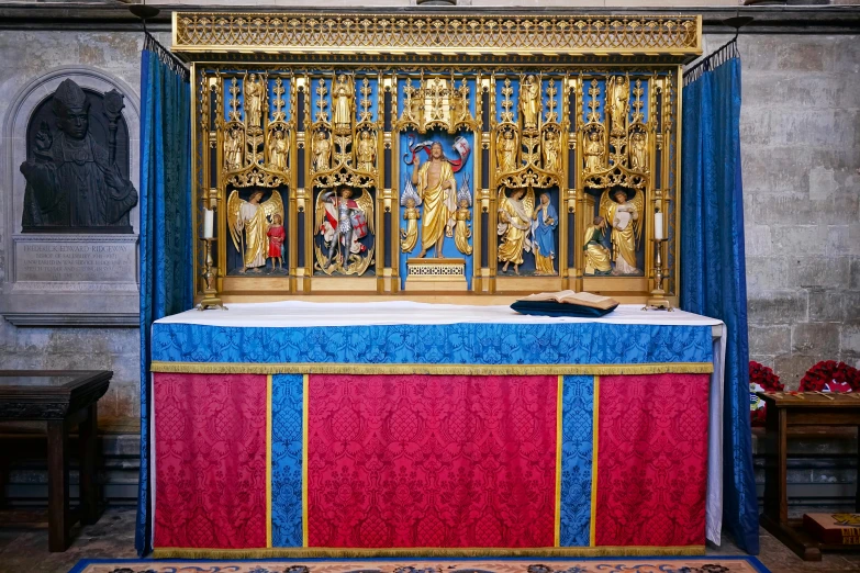 a church alter with a red, blue and gold cloth