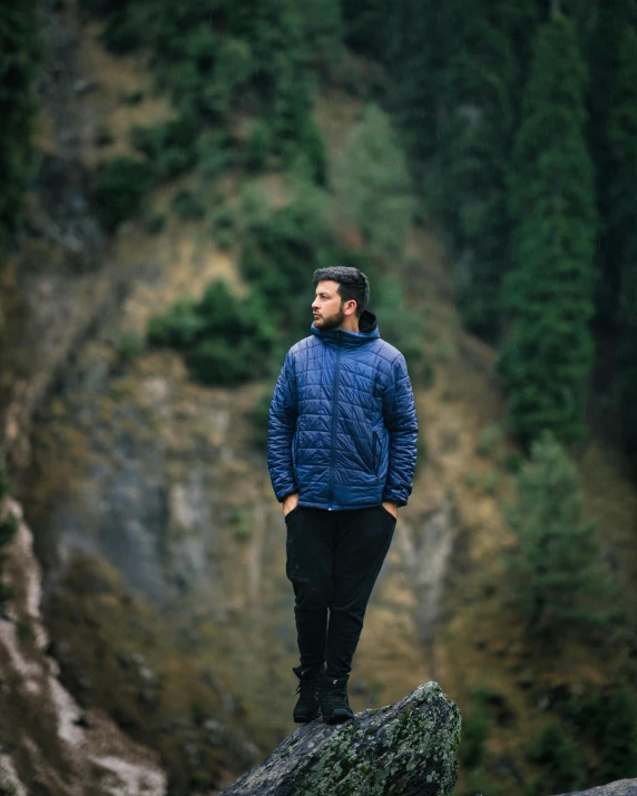 a man standing on top of a mountain overlooking a falls