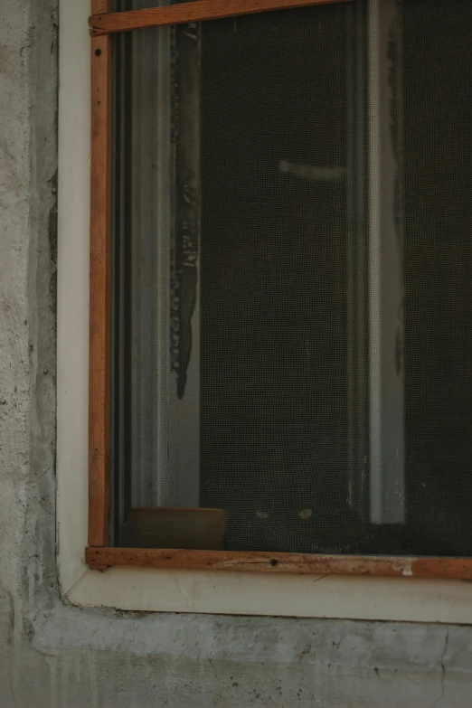 a window with a wooden frame is sitting inside a building