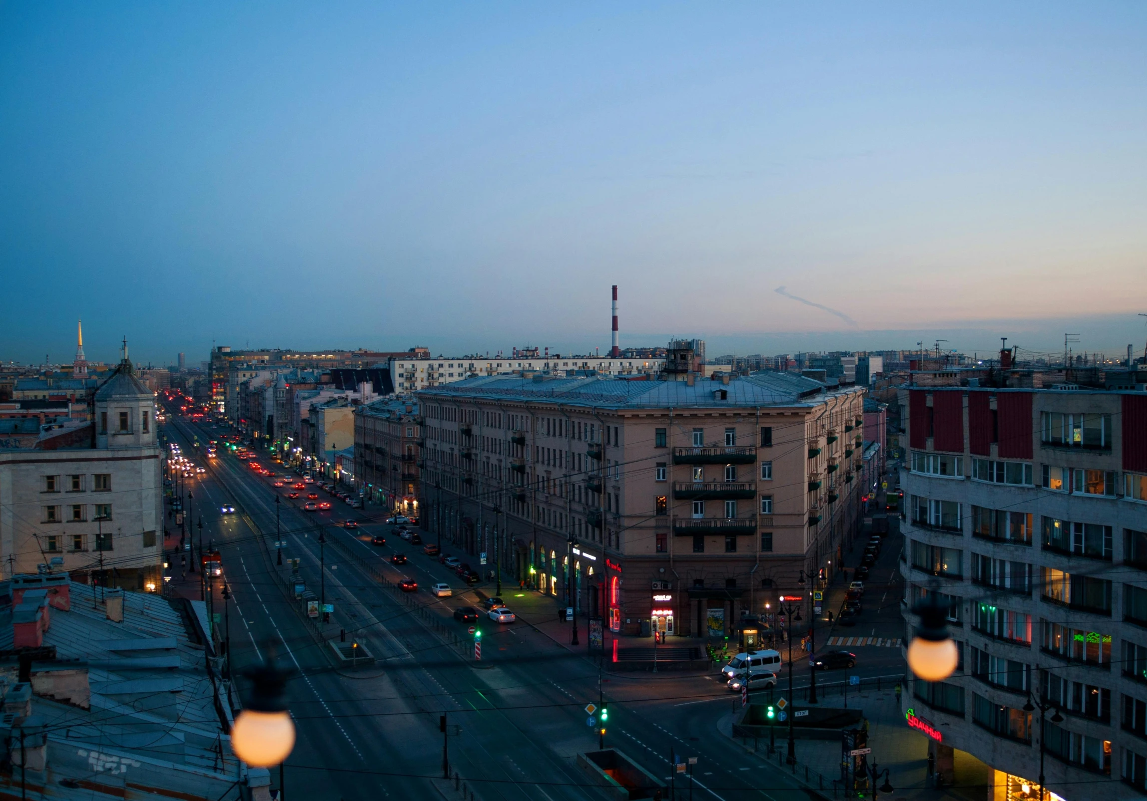 a city street at dusk with several buildings