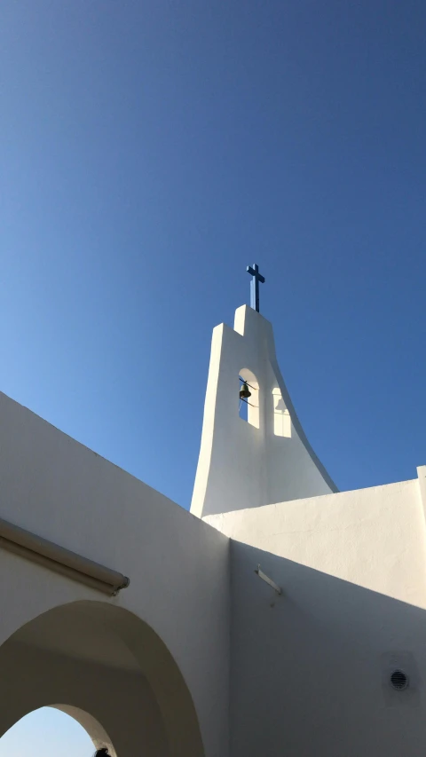 a person is standing under a white cross