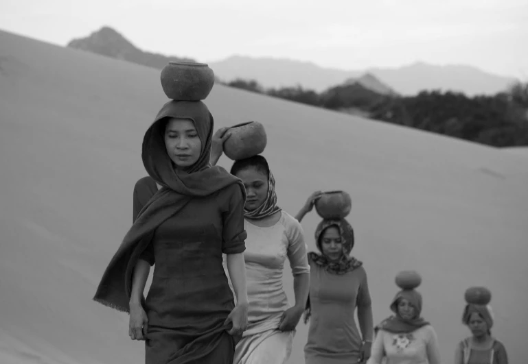 a bunch of ladies wearing hats walking down a hill